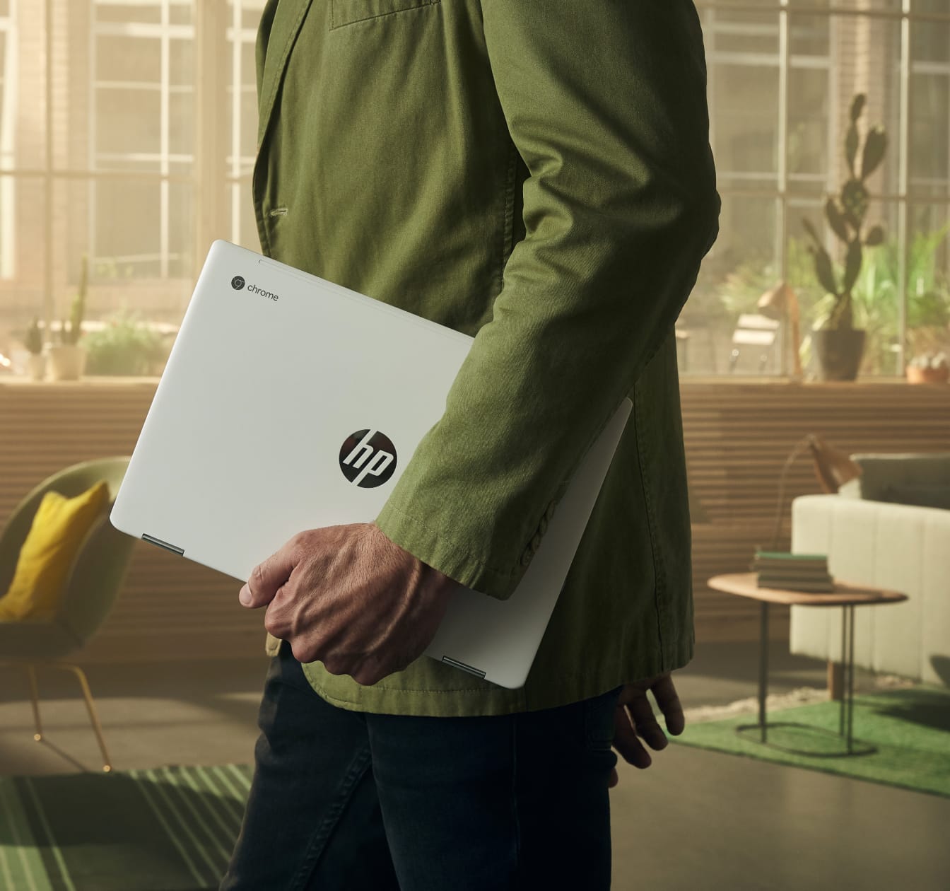Man walking through a workspace with a HP Chromebook. The long battery life of Chromebooks make them easy to take on the go.