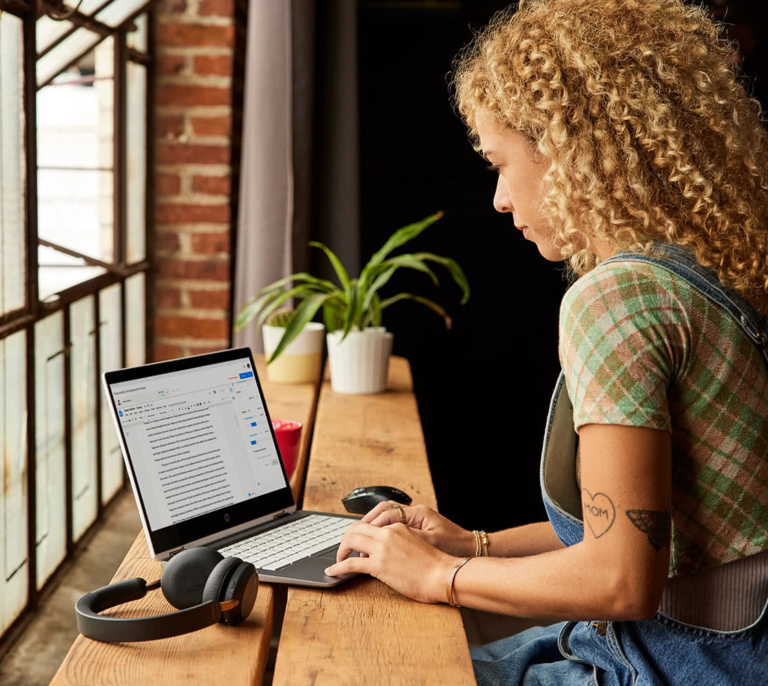 Woman shows a friend how easy it is to switch to Chromebook over drinks in a european coffee house.